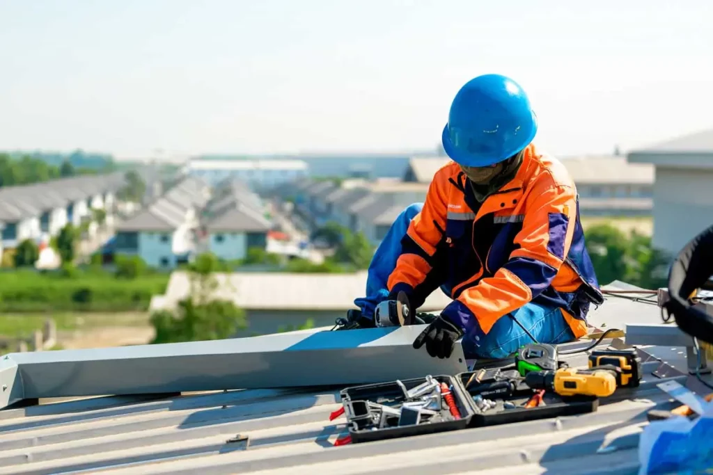 Construction worker using a drill to secure roofing materials on a commercial building – get more calls and roofing leads with a results driven roofer marketing agency