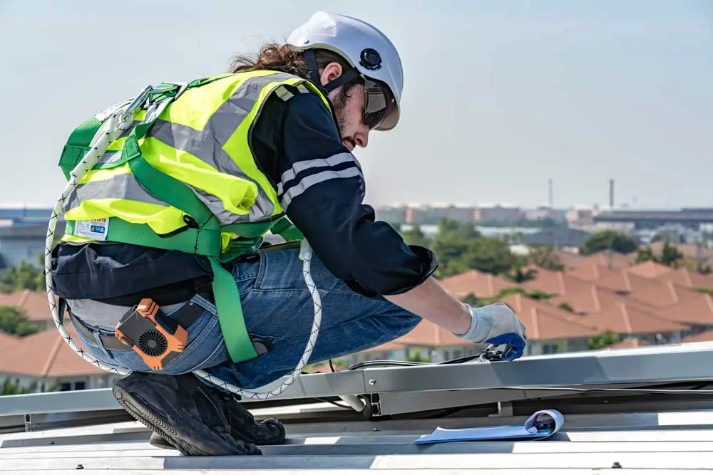 Roofer inspecting or installing roof equipment with a safety harness great fit for roofing marketing services offering commercial roofing solutions